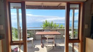 a balcony with a table and chairs on a deck at The Rock in Tuateawa