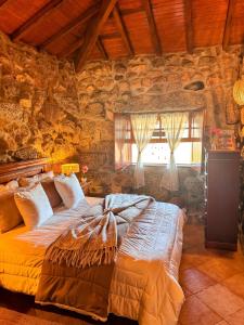 a bedroom with a large bed in a stone wall at Casa do Monte Sereno in Celorico de Basto +74 photos