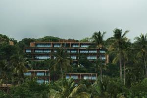 an office building with palm trees in front of it at Siari Riviera Nayarit, a Ritz-Carlton Reserve in El Divisadero