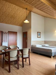 a room with a bed and a table and chairs at Bursztynowy Brzeg in Sarbinowo