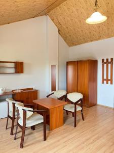 a dining room with a wooden table and chairs at Bursztynowy Brzeg in Sarbinowo