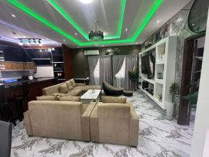 a living room with green lights on the ceiling at Afia Cottage Inn in Ayaso