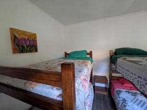 a bedroom with two beds and a painting on the wall at Hostel INK - Duerme Como En Casa in Concepción