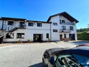 a white house with a car parked in front of it at Pokoje Gościnne "Cyprian" in Siedlce