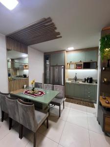 a kitchen with a green dining room table and chairs at Lindo apartamento todo equipado in Criciúma