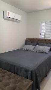 a bedroom with a large bed with a brown headboard at Lindo apartamento todo equipado in Criciúma