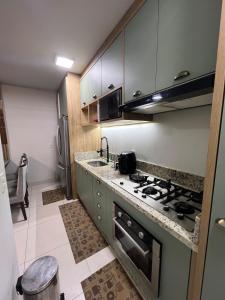 a kitchen with a sink and a stove top oven at Lindo apartamento todo equipado in Criciúma +5 photos