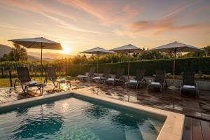 a swimming pool with chairs and umbrellas at Casa Luna in Ravna Gora