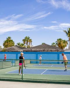 Eine Gruppe von Menschen spielt Tennis auf einem Tennisplatz in der Unterkunft Hotel Playa Del Sol in Los Barriles