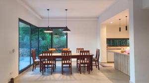 a kitchen and dining room with a table and chairs at Bustani Villa in Nyamanzi Kazole