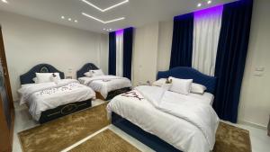 a bedroom with two beds with white sheets and purple curtains at Queen Inn Pyramids View in Cairo