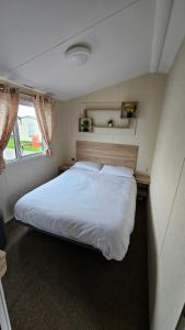 a bedroom with a large white bed in a room at Great Yarmouth 10 Berth KP Holiday Home - NOW with Linen in Corton +14 photos