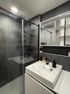 a bathroom with a white sink and a shower at Smarty Choice Living with FREE PARKING - Vondroušova in Prague