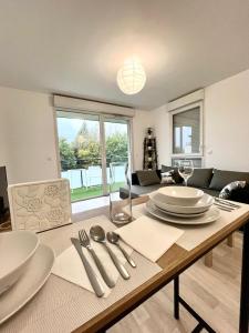 a dining room with a table with plates and silverware at Villeneuve, in Villeneuve d'Ascq