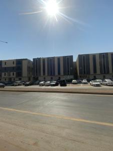 a parking lot with cars parked in front of a building at Condo in Alramal near to the airport in Riyadh