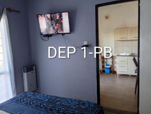 a room with a tv on a wall with a bed at Alquituc Escobar in Belén de Escobar