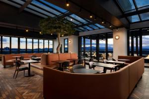 a restaurant with tables and chairs and windows at Aloft by Marriott Asheville Downtown in Asheville