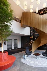 a lobby with a staircase and chairs and a tree at citizenM Rotterdam in Rotterdam +34 photos
