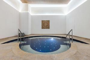a swimming pool in a white room with a ceiling at Istanbul Marriott Hotel Sisli in Istanbul