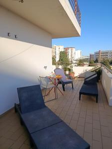 a balcony with chairs and a table on a building at BellaVita City Faro in Faro