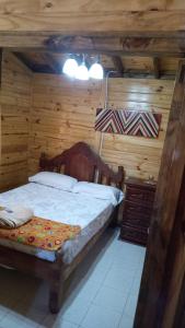 a bedroom with a bed and a wooden wall at Cabaña El Refugio in La Carrera +5 photos