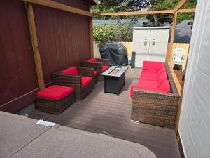 a patio with wicker chairs and a table with red cushions at Beach Bum Cabin in Florence