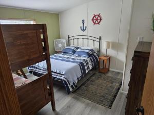 a bedroom with a bed and a wooden floor at Beach Bum Cabin in Florence