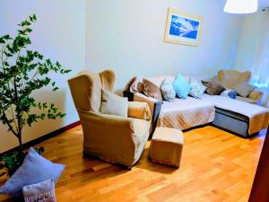 a living room with a couch and two chairs at Apartamento Fomento in Gijón
