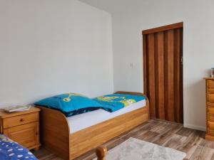 a bedroom with a bed and a wooden cabinet at Waldbühnenblick in Schwarzenberg/Erzgebirge +4 photos