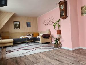 a living room with a couch and a clock on the wall at Waldbühnenblick in Schwarzenberg/Erzgebirge