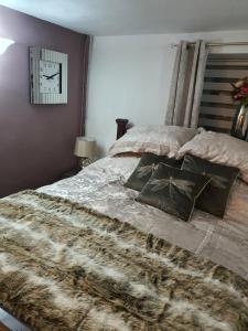 a bedroom with a bed and a clock on the wall at Lamb Cottage Bed and Breakfast in Box