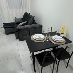 a black table and chairs in a living room at Apto Cozi in Sorriso +4 photos