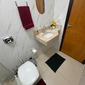 a bathroom with a toilet and a sink at Apto Cozi in Sorriso