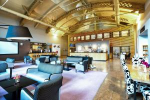 a waiting room with blue couches and a bar at Four Points by Sheraton Offenbach Plaza in Offenbach
