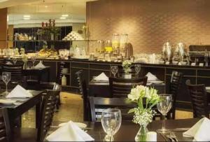 a restaurant with tables and chairs and a bar at StudioTriplo Superior Completo 608- Casal e Solteiro ou 3 Solteiros in Barueri