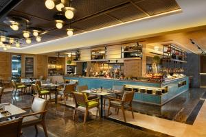 a restaurant with tables and chairs and a bar at Courtyard by Marriott Bali Seminyak Resort in Seminyak