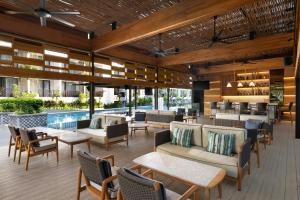 a restaurant with a pool and tables and chairs at Courtyard by Marriott Bali Seminyak Resort in Seminyak