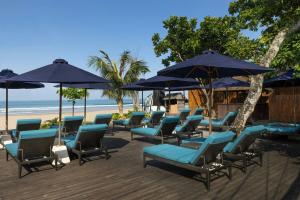 a bunch of chairs and umbrellas on a beach at Courtyard by Marriott Bali Seminyak Resort in Seminyak