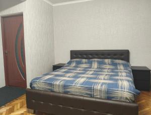 a bed with a blue and white comforter in a room at Apartament Balti in Bălţi
