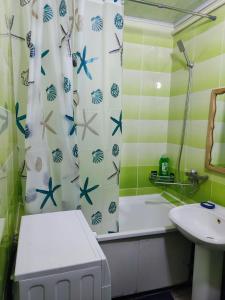 a bathroom with a tub and a sink and a shower curtain at Apartament Balti in Bălţi