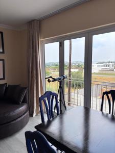a living room with a table and a view of a balcony at Hyalus House in Vaal Marina
