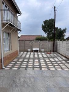 a patio with a bench in front of a building at Hyalus House in Vaal Marina