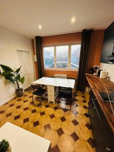 a kitchen with a table and chairs in a room at Appartement Lumineux 2 in Tourcoing
