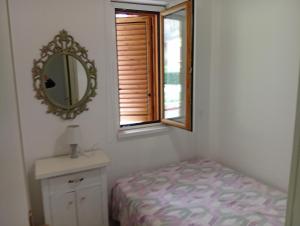 a small bedroom with a mirror and a bed at Casa Torre in Fiumefreddo Bruzio +5 photos