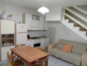 a kitchen and living room with a couch and a table at Casa Torre in Fiumefreddo Bruzio
