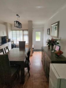 a kitchen and dining room with a wooden table and chairs at Lancing in Lancing