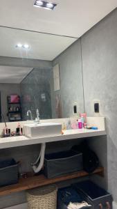 a bathroom with a sink and a mirror at jaó, mazzahome in Goiânia