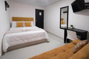 a bedroom with a bed and a couch and a mirror at HOTEL BIG BEN MALAGA SANTANDER in Málaga