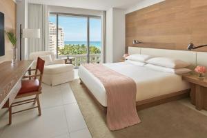 a hotel room with a bed and a desk and a balcony at The Miami Beach EDITION in Miami Beach +55 photos