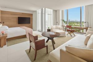 a hotel room with a bed and a living room at The Miami Beach EDITION in Miami Beach